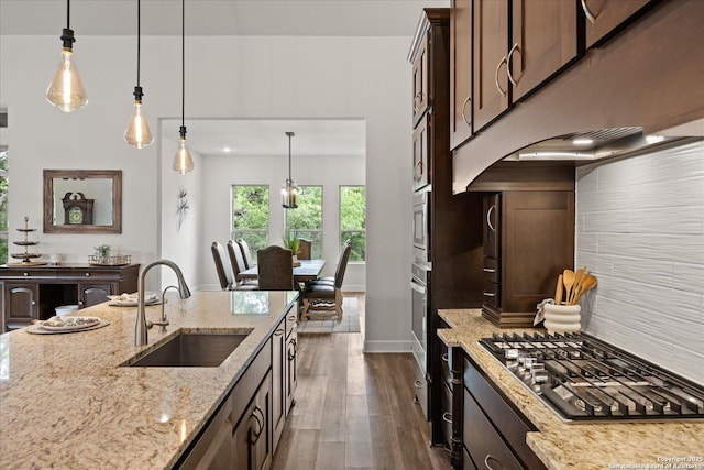 110 Madrone Trl, Boerne, TX 78006 - kitchen featuring dark brown cabinets, hanging light fixtures, a sink, stainless steel appliances, and dark wood-style flooring