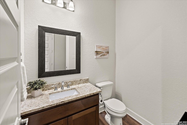 110 Madrone Trl, Boerne, TX 78006 - half bath with toilet, a textured wall, vanity, and wood finished floors