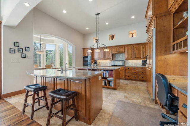 4001 Bell Springs Rd, Dripping Springs, TX 78620 - kitchen with brown cabinets, built in microwave, an island with sink, backsplash, and open shelves