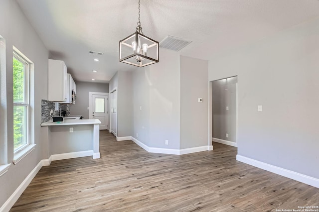 kitchen featuring light wood-type flooring, a wealth of natural light, visible vents, and an inviting chandelier