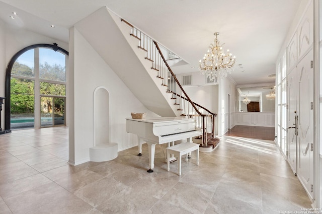 entryway featuring visible vents, stairs, and an inviting chandelier
