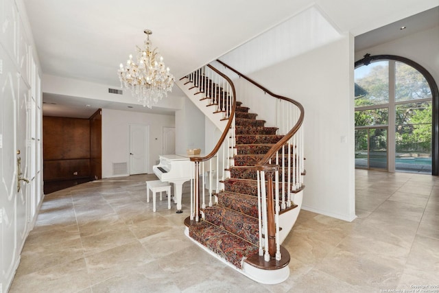 staircase with baseboards, visible vents, and a notable chandelier