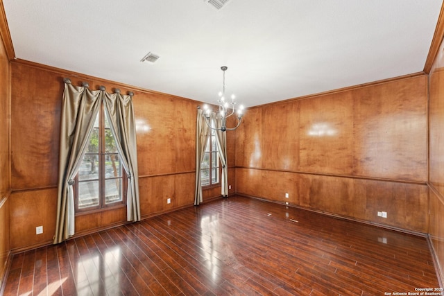 interior space featuring dark wood-style floors, visible vents, a notable chandelier, wooden walls, and ornamental molding