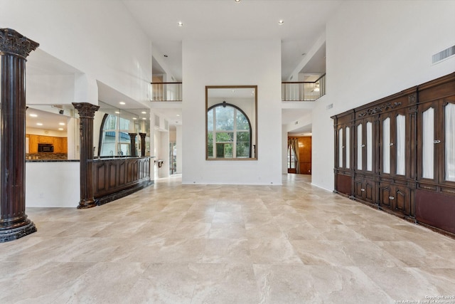 entryway featuring a towering ceiling, decorative columns, visible vents, and recessed lighting