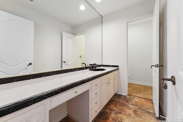 bathroom featuring toilet, vanity, baseboards, stone finish floor, and recessed lighting