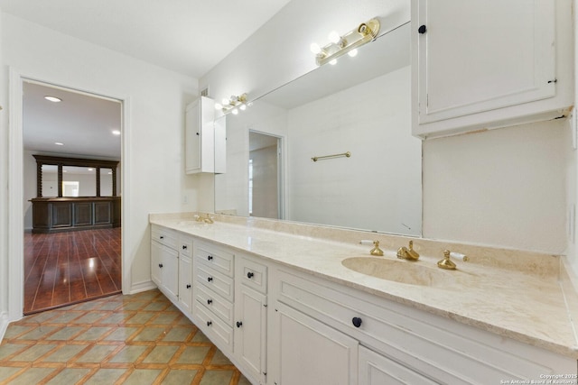 bathroom with tile patterned floors, a sink, and double vanity