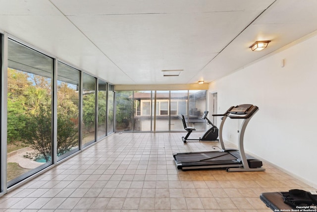 workout room featuring expansive windows, baseboards, and light tile patterned flooring