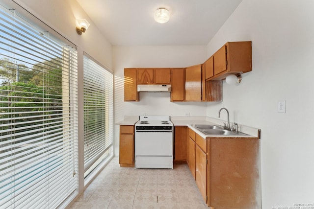 kitchen with white electric range oven, under cabinet range hood, a sink, and light countertops