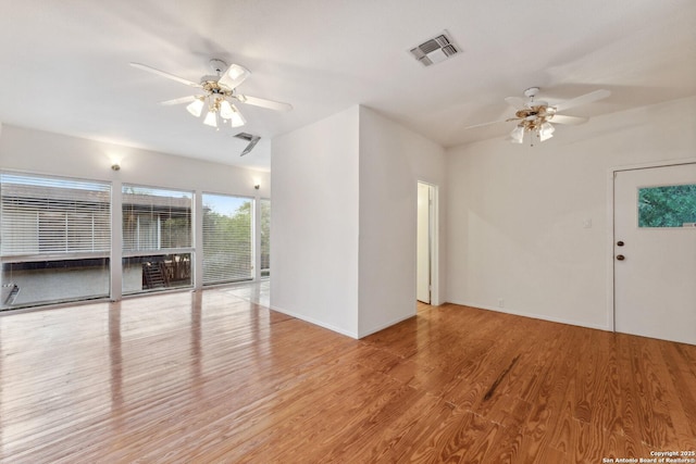 unfurnished living room featuring wood finished floors, baseboards, a ceiling fan, and visible vents
