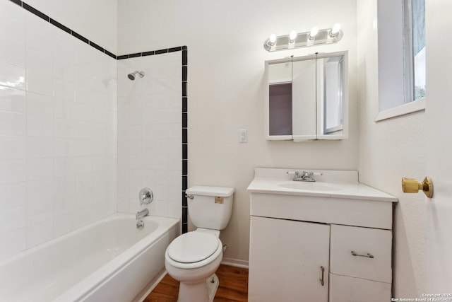 bathroom with wood finished floors, vanity, shower / tub combination, baseboards, and toilet