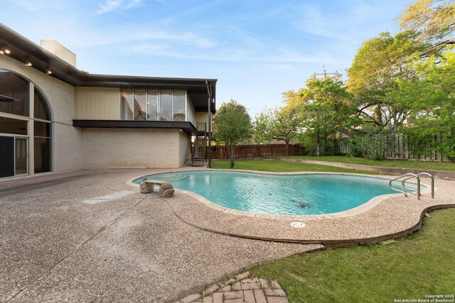 view of pool featuring stairway, a lawn, a fenced backyard, a patio, and a fenced in pool
