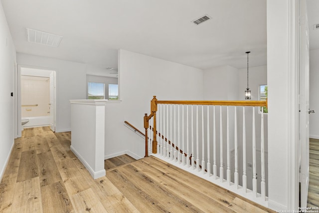 810 Eight Iron, San Antonio, TX 78221 - corridor with baseboards, wood finished floors, visible vents, and an upstairs landing