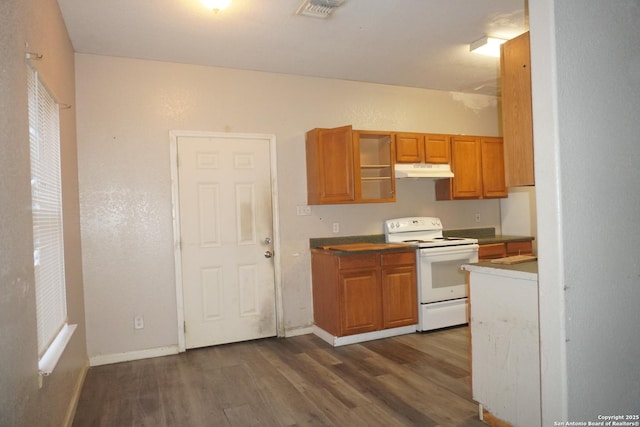 8826 Dream Ave, Converse, TX 78109 - kitchen with brown cabinets, dark wood finished floors, under cabinet range hood, white range with electric stovetop, and visible vents
