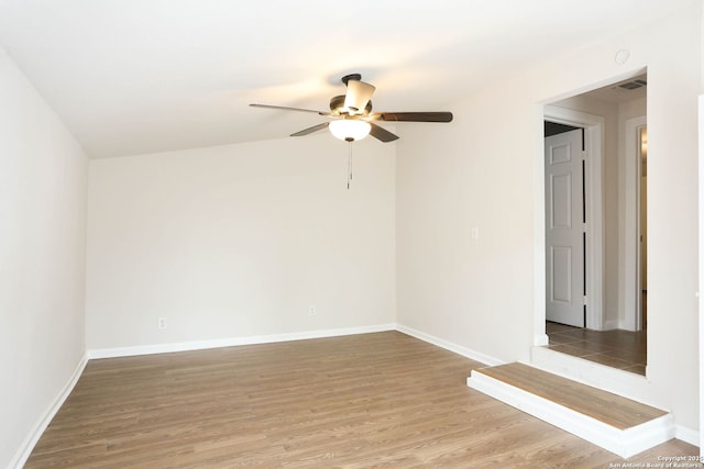 unfurnished room featuring a ceiling fan, baseboards, and light wood-style flooring