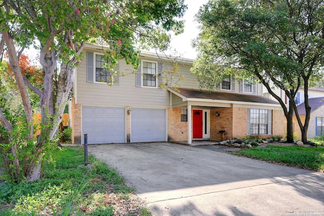 traditional home with a garage, driveway, and brick siding