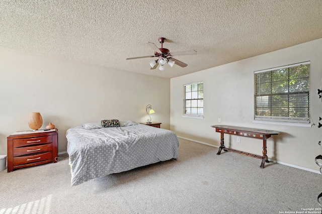carpeted bedroom with baseboards, a ceiling fan, and a textured ceiling