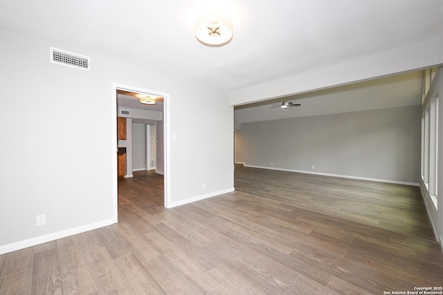unfurnished room featuring ceiling fan, baseboards, wood finished floors, and visible vents