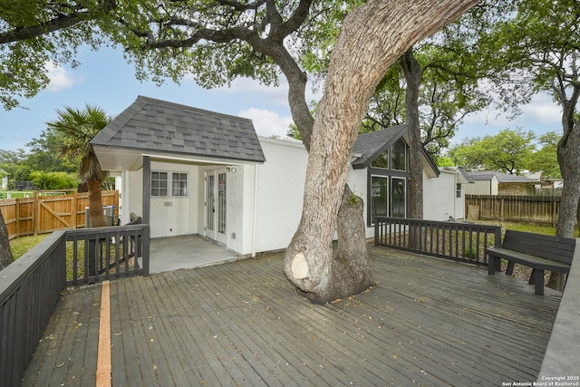 wooden deck with a fenced backyard and french doors