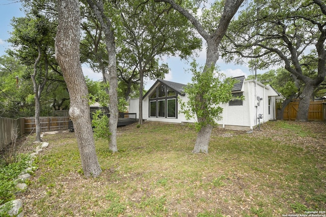rear view of house featuring a fenced backyard and a yard