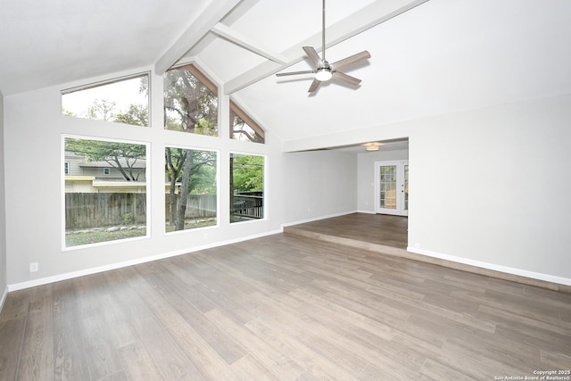 unfurnished living room featuring wood finished floors, a ceiling fan, baseboards, and beam ceiling