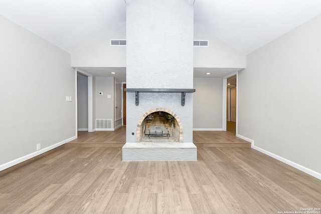 unfurnished living room with a fireplace, visible vents, and high vaulted ceiling