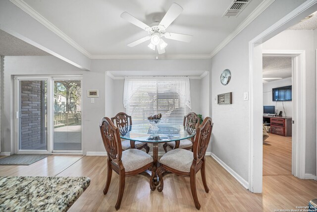 dining space featuring crown molding, light wood-type flooring, ceiling fan, baseboards, and visible vents