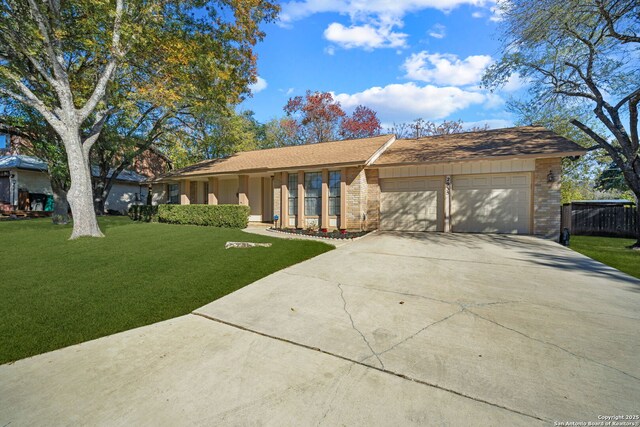 single story home featuring an attached garage, a front lawn, driveway, and fence