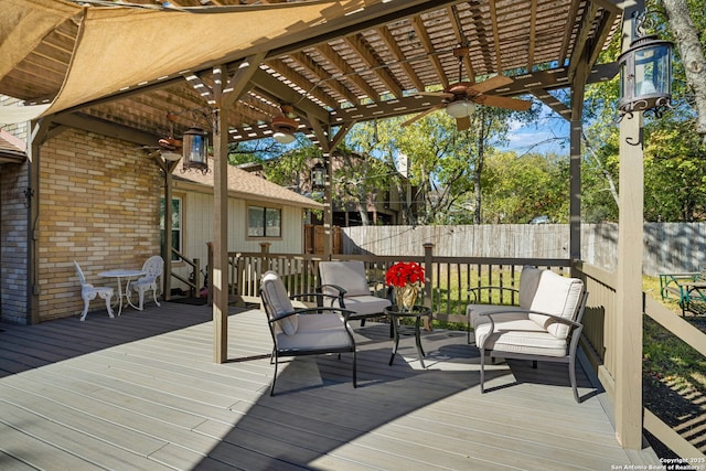 wooden deck featuring ceiling fan, a fenced backyard, and a pergola