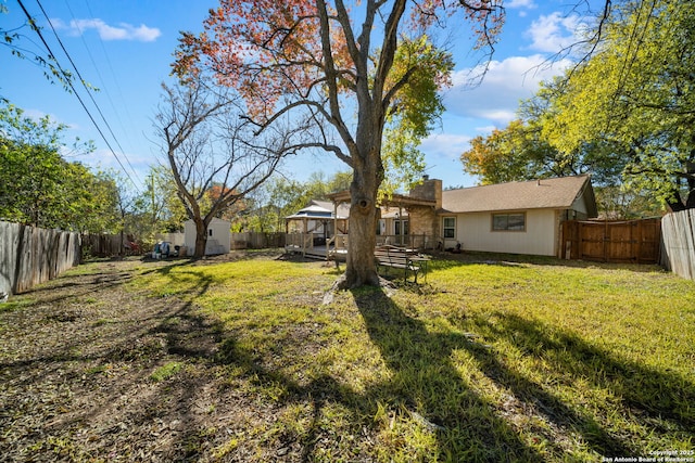 view of yard with a storage shed, a fenced backyard, an outbuilding, and a gazebo