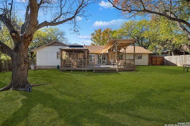 back of house with a gazebo, a lawn, a fenced backyard, and a wooden deck