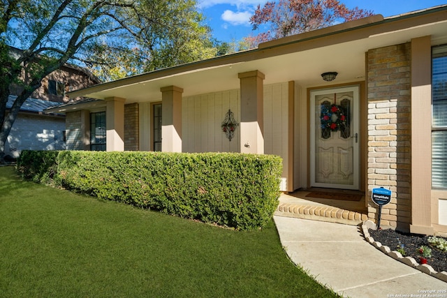entrance to property with a lawn