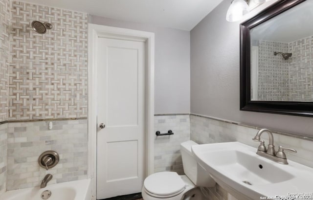 1244 Clower, San Antonio, TX 78201 - bathroom with tile walls, a sink, toilet, a wainscoted wall, and  shower combination
