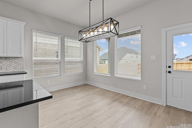 133 Bailey Blf, San Antonio, TX 78253 - unfurnished dining area featuring a chandelier, light wood-type flooring, and baseboards