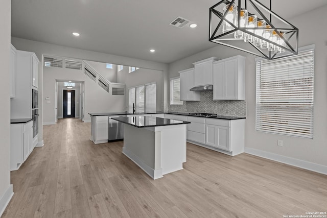 133 Bailey Blf, San Antonio, TX 78253 - kitchen featuring dark countertops, a peninsula, under cabinet range hood, stainless steel dishwasher, and gas cooktop