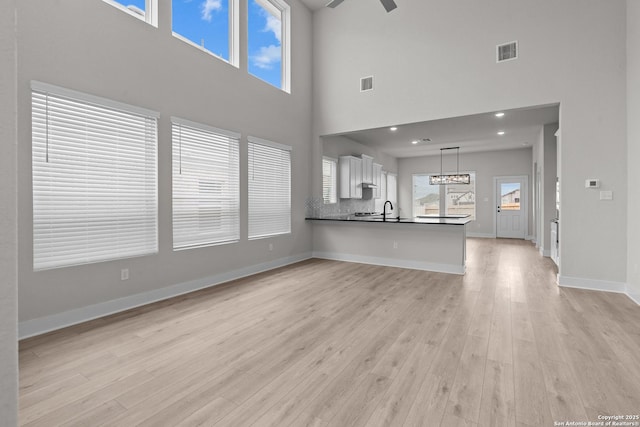 133 Bailey Blf, San Antonio, TX 78253 - unfurnished living room featuring light wood-style floors, a towering ceiling, and visible vents