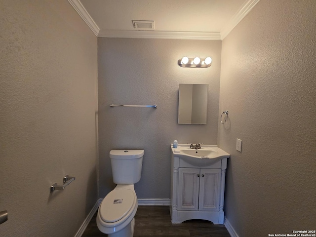 5026 Pine Lk, San Antonio, TX 78244 - half bathroom featuring crown molding, wood finished floors, vanity, toilet, and visible vents