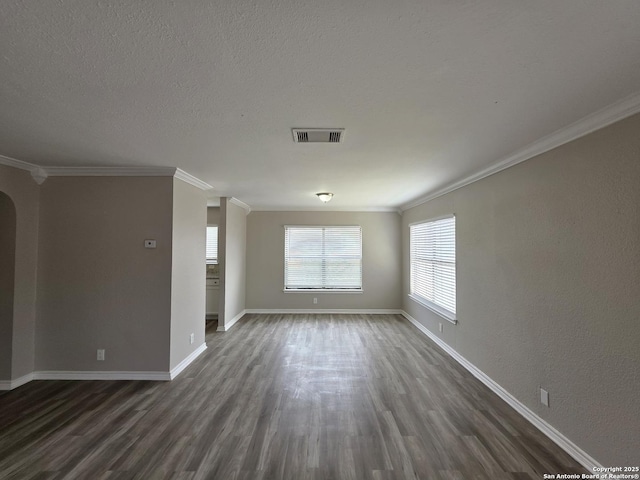 5026 Pine Lk, San Antonio, TX 78244 - interior space featuring dark wood-style floors, visible vents, arched walkways, crown molding, and baseboards