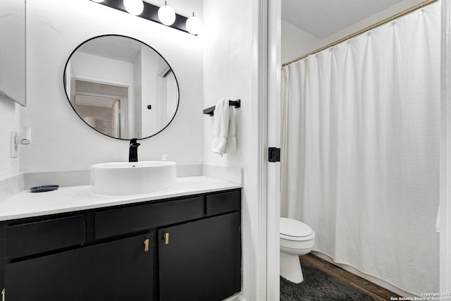 6807 Burnley, San Antonio, TX 78239 - bathroom with toilet, a shower with shower curtain, vanity, and wood finished floors