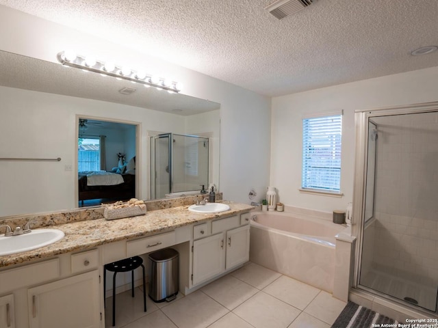 ensuite bathroom featuring a shower stall, double vanity, visible vents, and a sink