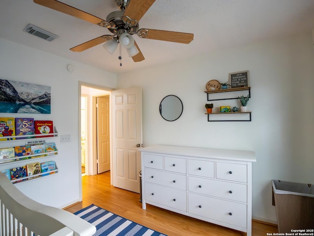 bedroom with a ceiling fan, visible vents, and light wood-type flooring
