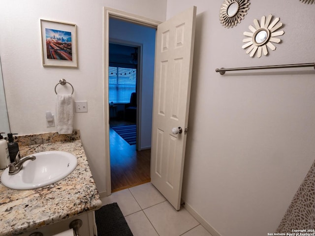 bathroom with baseboards, vanity, and tile patterned floors