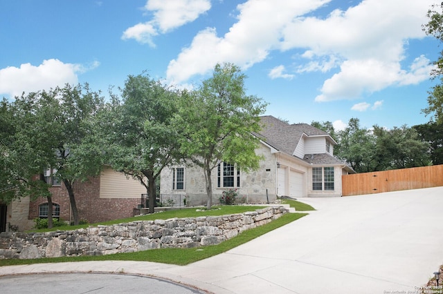 3110 Bonita Spgs, San Antonio, TX 78258 - view of front facade with driveway, fence, a garage, brick siding, and a shingled roof