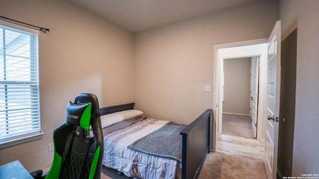 bedroom featuring light carpet and multiple windows