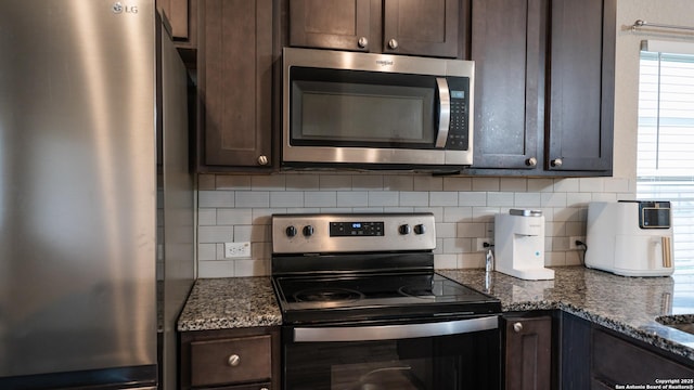 kitchen with dark stone counters, decorative backsplash, dark brown cabinetry, and appliances with stainless steel finishes