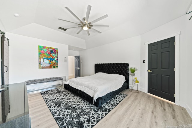 bedroom with light wood-type flooring, visible vents, a ceiling fan, and baseboards