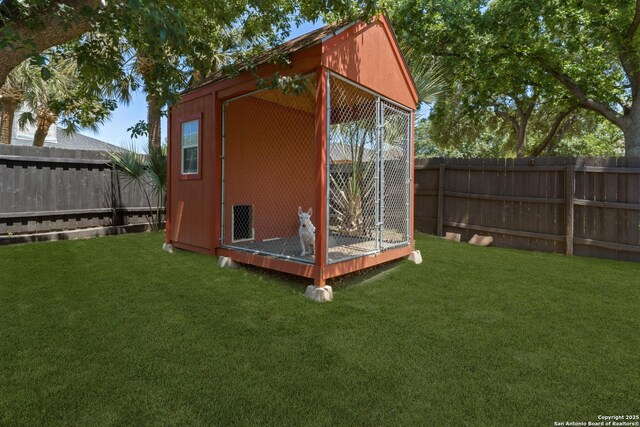 view of outdoor structure featuring a fenced backyard, an outbuilding, and an exterior structure
