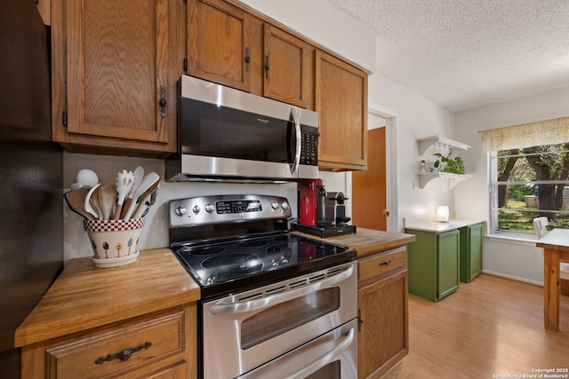 9416 Geronimo Vw, San Antonio, TX 78254 - kitchen featuring appliances with stainless steel finishes, open shelves, light wood-style flooring, a textured ceiling, and brown cabinetry