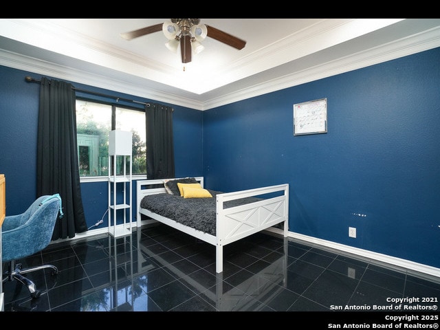 bedroom featuring a raised ceiling, baseboards, and ornamental molding