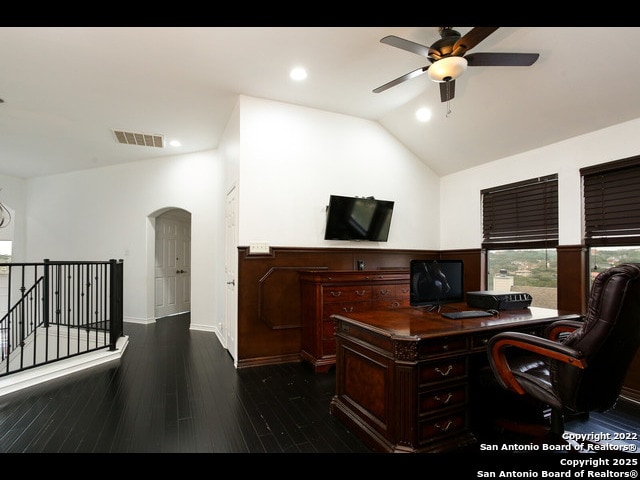 home office featuring arched walkways, visible vents, a ceiling fan, high vaulted ceiling, and dark wood-type flooring