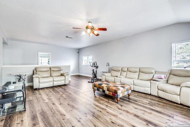 living room featuring a wealth of natural light, a ceiling fan, wood finished floors, and visible vents